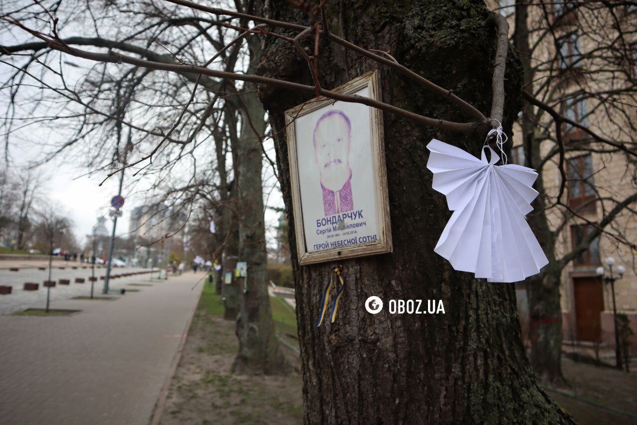 People carry flowers and light candles in Kyiv to honor heroes who died during the Revolution of Dignity. Photo