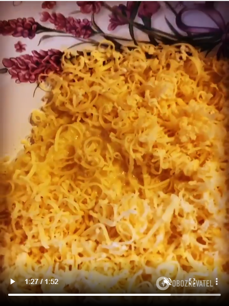 Adding grated cheese.