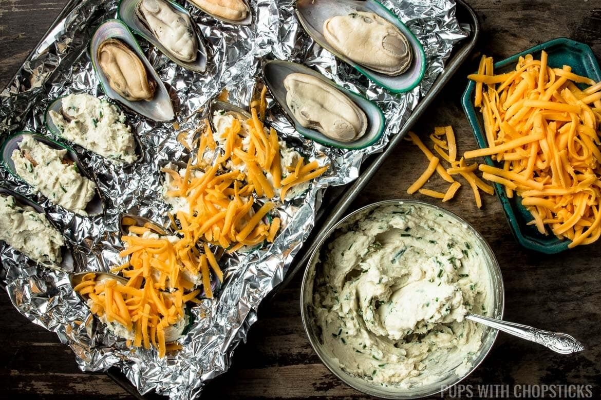 Brush the mussels with garlic butter and sprinkle with cheese.