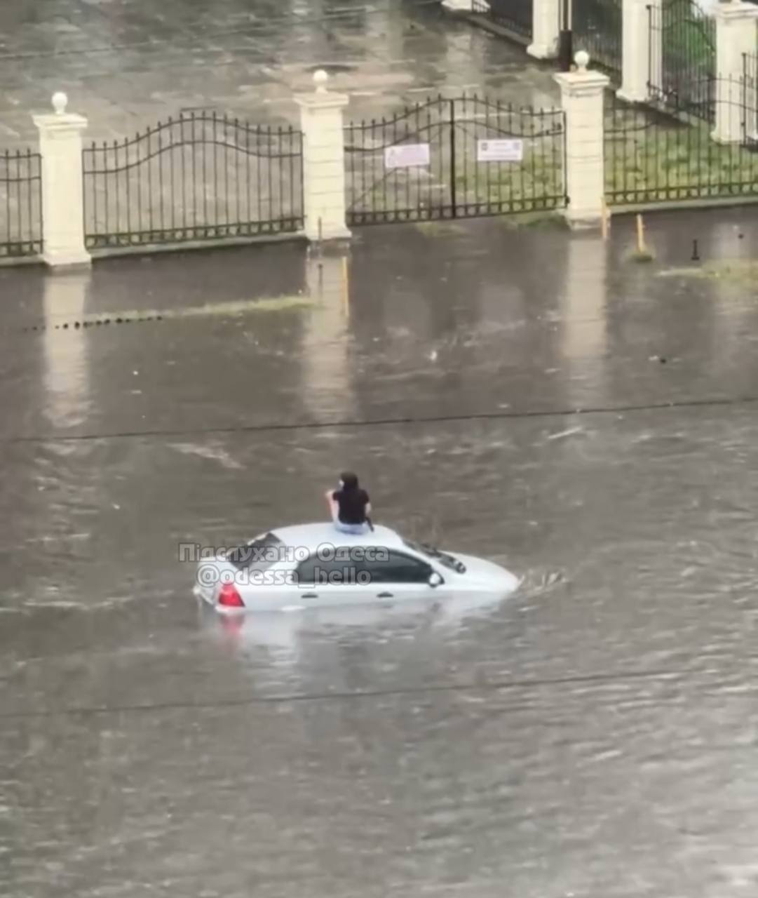 An Odessan woman sat on the roof of a flooded car.