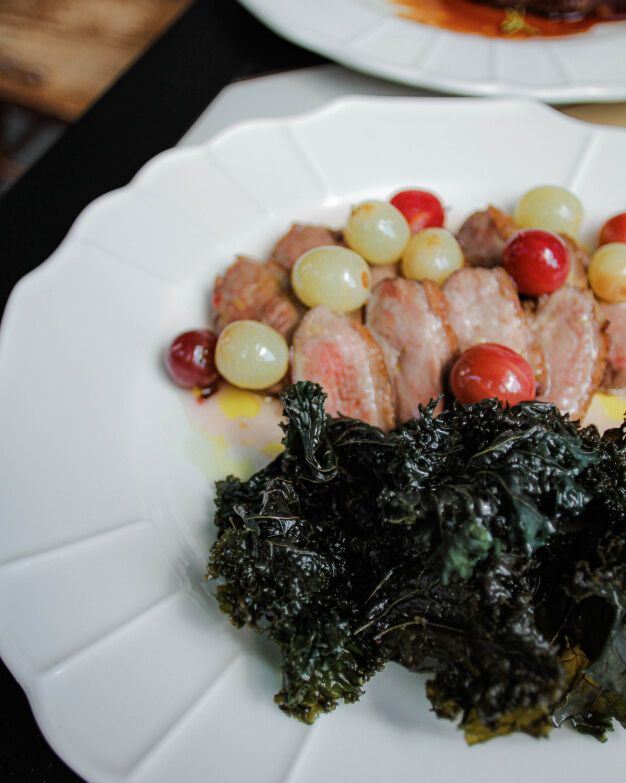 Duck breast with kale chips and grape and gooseberry sauce is prepared using the Su-weed technology