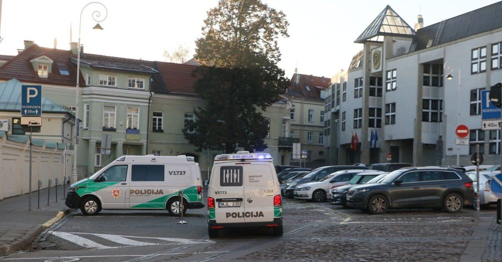 Pojazdy służb porządkowych w pobliżu budynku litewskiego Ministerstwa Obrony