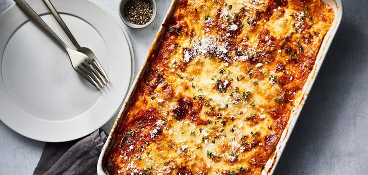 Meat under a "fur coat" with mushrooms, tomatoes and cheese: a recipe for a hearty dish