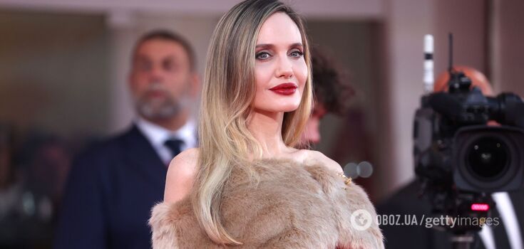 Angelina Jolie kneels on the red carpet. Touching photos